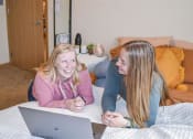 Thumbnail 13 of 32 - two women laying on a bed with a laptop at Boulder Ridge, Duluth, MN