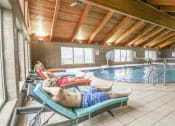 Thumbnail 2 of 32 - a man laying on a lounge chair next to a swimming pool at Boulder Ridge, Duluth