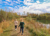 Thumbnail 5 of 32 - two women walking along a trail next to a lake at Boulder Ridge, Minnesota