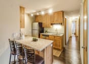 Thumbnail 2 of 27 - a kitchen with a marble counter top and wooden cabinets at Campus Park, Minnesota, 55811