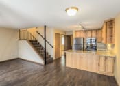 Thumbnail 12 of 27 - a living room with a kitchen and a staircase at Campus Park, Duluth, MN, 55811