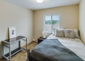 Thumbnail 15 of 27 - a bedroom with a bed and a desk and a window at Campus Park, Duluth, 55811