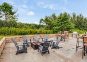 Thumbnail 9 of 27 - a patio with chairs and tables and a fire pit  at Campus Park, Duluth
