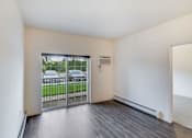 Thumbnail 29 of 35 - an empty living room with a door to a balcony at Arbor Ridge, Forest Lake, MN