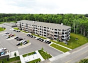 Thumbnail 20 of 35 - an aerial view of a large apartment building in a parking lot at Arbor Ridge, Forest Lake, MN, 55025