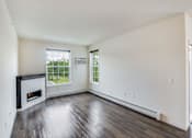 Thumbnail 31 of 35 - an empty living room with a fireplace and wooden floors at Arbor Ridge, Forest Lake, MN, 55025
