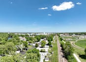 Thumbnail 9 of 16 - an aerial view of a city with trees and a train track