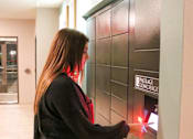Thumbnail 62 of 67 - a woman is pressing a button on a door of a parcel receiving system  at Timber Ridge, Forest Lake