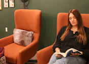 Thumbnail 55 of 67 - a woman sitting in a chair reading a book  at Timber Ridge, Forest Lake, MN, 55025