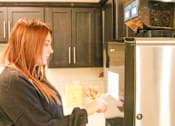 Thumbnail 54 of 67 - a woman standing in a kitchen putting food into a refrigerator  at Timber Ridge, Minnesota, 55025