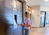 Thumbnail 47 of 67 - a woman picking up her package in the lobby  at Timber Ridge, Forest Lake