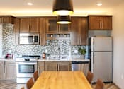 Thumbnail 8 of 67 - a kitchen with stainless steel appliances and a wooden table  at Timber Ridge, Minnesota, 55025