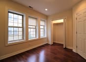 Thumbnail 9 of 13 - an empty living room with wood floors and large windows