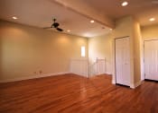 Thumbnail 8 of 13 - an empty living room with wooden floors and a ceiling fan