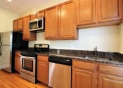 Thumbnail 5 of 13 - a kitchen with stainless steel appliances and wooden cabinets