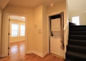 Thumbnail 13 of 13 - a room with stairs and a refrigerator and a washer and dryer in it