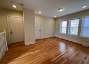 Thumbnail 7 of 13 - an empty living room with wooden floors and a white door