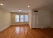 Thumbnail 6 of 13 - an empty living room with wooden floors and a door to a closet