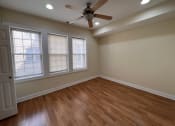 Thumbnail 11 of 13 - an empty living room with a ceiling fan and windows