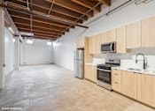 Thumbnail 6 of 57 - A kitchen with wooden cabinets and stainless steel appliances.