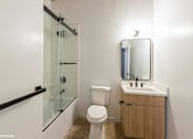 Thumbnail 14 of 57 - A white toilet sits next to a sink in a small bathroom.
