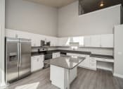 Thumbnail 2 of 25 - a large kitchen with stainless steel appliances and white cabinets