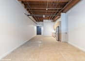 Thumbnail 10 of 57 - A long, empty hallway with a door at the end and a refrigerator on the side.