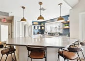 Thumbnail 14 of 20 - A modern kitchen with a large island and chairs.