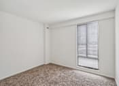 Thumbnail 19 of 82 - a bedroom with a large window and a carpeted floor
