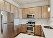 Thumbnail 3 of 45 - A kitchen with wooden cabinets and stainless steel appliances.