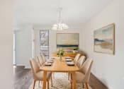 Thumbnail 2 of 82 - A dining room with a wooden table and chairs.