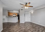 Thumbnail 25 of 40 - Open-concept living room with wood-style flooring, breakfast bar, ceiling fan, and kitchen in a 1-bedroom apartment home at Gregory Cove in Jacksonville, FL.