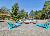 Thumbnail 20 of 26 - A sunny day at a picnic area with blue benches and umbrellas.