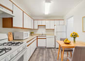 Thumbnail 1 of 82 - A kitchen with a white gas stove and a white refrigerator.