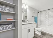 Thumbnail 13 of 40 - a white bathroom with a white toilet and a tub and a sink