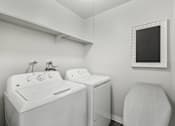 Thumbnail 10 of 40 - a white washer and dryer in a white laundry room with a white sink