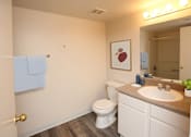 Thumbnail 6 of 26 - A bathroom with a toilet, sink, mirror, and lighted mirror.