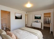 Thumbnail 4 of 26 - A bedroom with a bed, a cabinet, and two pictures on the wall.