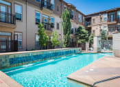 Thumbnail 22 of 25 - a swimming pool with an apartment building in the background