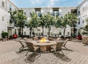 Thumbnail 18 of 25 - a fire pit in the middle of a patio with chairs and tables
