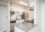 Thumbnail 15 of 40 - Kitchen with white cabinets and stainless steel counter tops  at Avery Park in Englewood, CO
