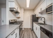 Thumbnail 14 of 40 - Kitchen with stainless steel appliances and white cabinets  at Avery Park in Englewood, CO