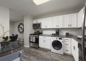 Thumbnail 22 of 82 - PLATINUM Kitchen with built in washer/dryer combo at Trillium Apartments, Fairfax