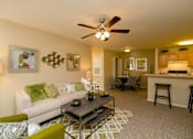 Thumbnail 5 of 17 - A living room with a white couch and a coffee table.