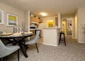 Thumbnail 6 of 17 - A dining table with two grey chairs and a carpet in a room.
