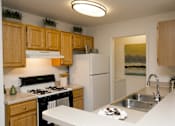 Thumbnail 8 of 17 - A kitchen with a black stove top oven and a white refrigerator.