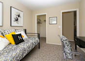 Thumbnail 12 of 17 - A bedroom with a bed, chair, and two pictures on the wall.
