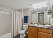 Thumbnail 15 of 44 - A bathroom with a white toilet, a white sink, and a white bathtub.