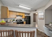 Thumbnail 5 of 44 - A kitchen with wooden cabinets and a grey countertop.