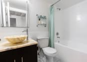 Thumbnail 9 of 18 - a bathroom with a sink and a toilet and a shower
